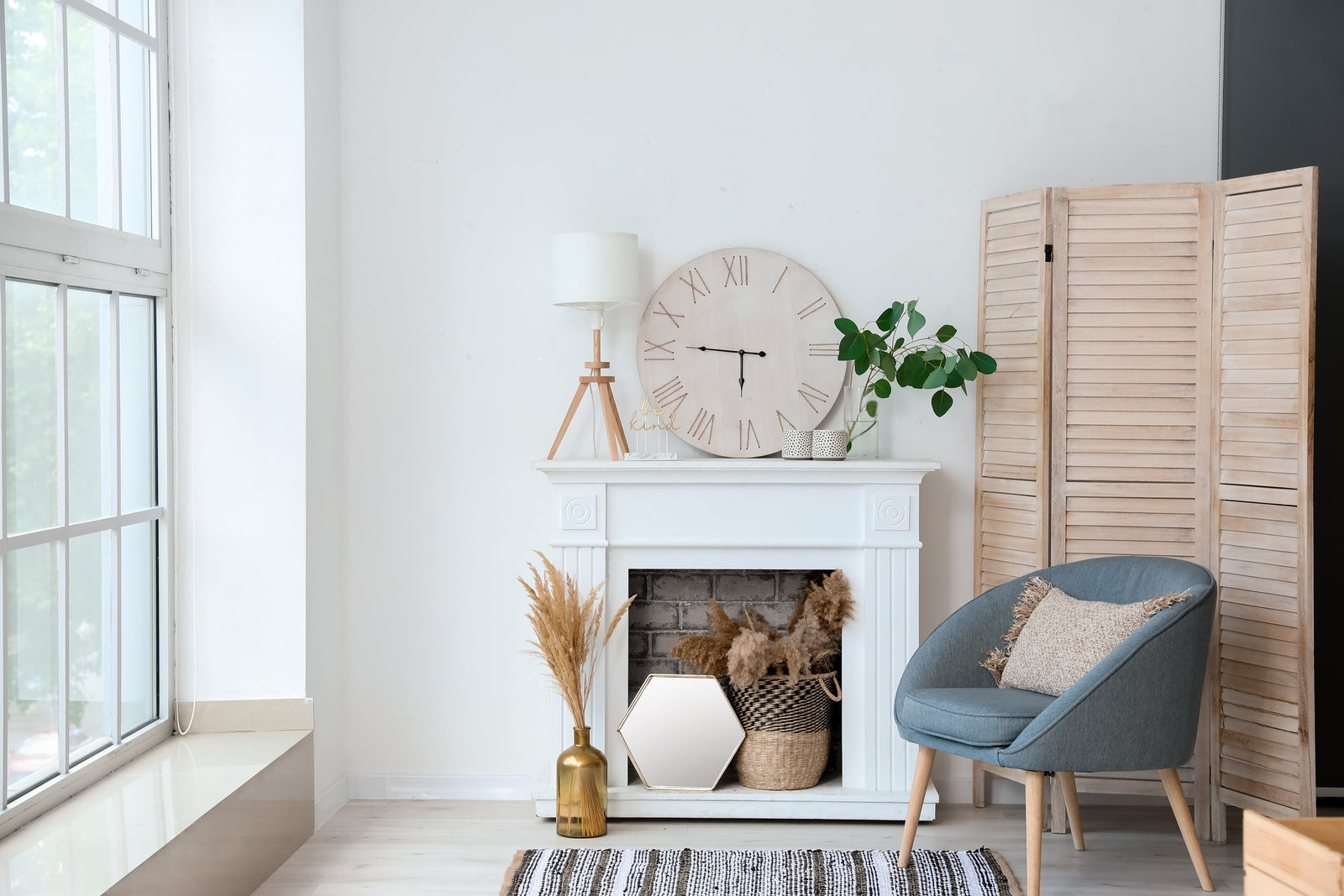 White painted brick fireplace with stacked firewood in the firebox and framed art on the mantel