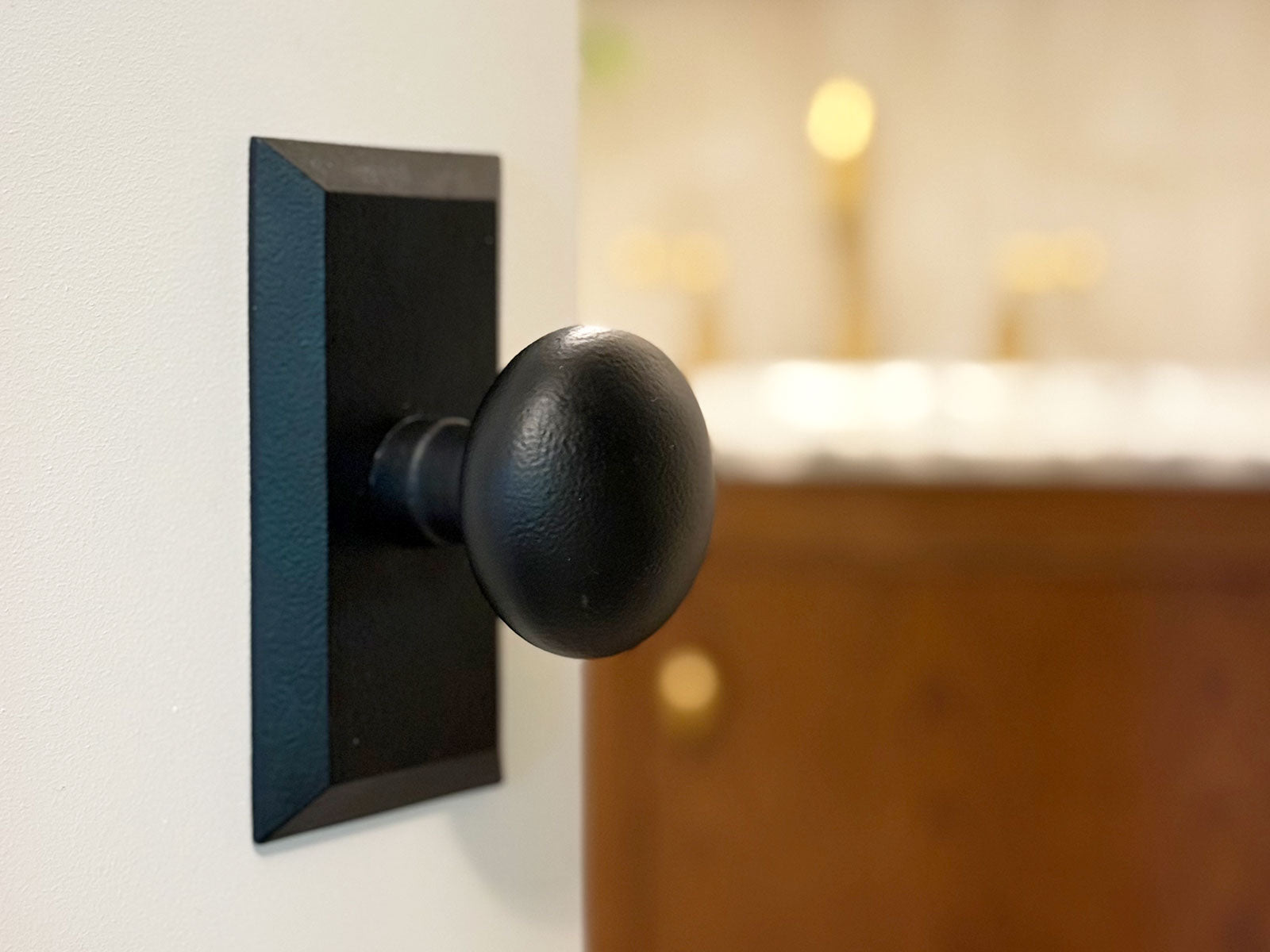 Interior bathroom door fitted with Ageless Iron’s black iron knob blending vintage and modern styles.
